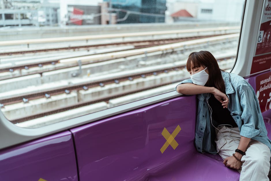 Woman in mask resting on a train