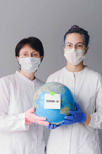 Medical staff holding globe with COVID-19 safety note